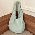 Détail de la texture plissée verticale vert pâle et de l'étiquette en tissu du sac - vert clair