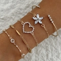 Gros plan sur un ensemble de bracelets dorés avec breloques fleurs et cœurs - Set de 5 Pièces Fleur Cœur Cristal Blanc Or(23579-bra-white)