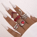 Set di cinque anelli serpente argento e cuore rosso indossati su mano da modella - Stile Cuore di Serpente con Gemma Rossa (19656-silveren red)