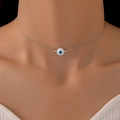 Collana minimalista in argento con ciondolo occhio blu sul collo di una modella - Collana / Argento