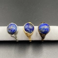 Lapis lazuli wire wrapped bead rings in silver, gold, and bronze finishes on a display - Lapis Lazuli