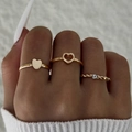 Three-piece set of golden fashion rings with heart motifs and zircon inlay on a model - Gold Zirconia Heart Style (30285-ring-G)