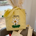 Close-up of yellow canvas tote bag featuring daisy embroidery and drawstring closure - Yellow (Sunflower Drawstring Tote Bag)
