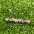 Handmade silver hair clip with pink crystal stone wrap on green grass background - Strawberry Quartz