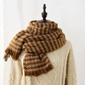 Sciarpa in maglia a quadri marrone e beige con nappe su un maglione a trecce crema - Marrone