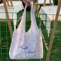 Floral print cotton tote bag with Gentle Soul script on outdoor grass background - Blue Floral Vest Bag
