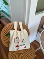 Close-up of cream canvas tote bag with embroidered apple patterns and I like apple text - Beige Apple Embroidery Style
