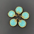 Handmade gold wire-wrapped turquoise pendants set arranged on a black textured background - Blue Turquoise (Synthetic)