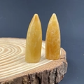 Piedras de citrino amarillo en forma de bala sobre una base de madera natural - Topacio