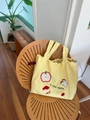 Light yellow tote bag with apple embroidery and drawstring closure on a wooden chair - Yellow Apple Embroidery Style