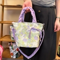 Dettaglio della borsa a secchiello in tela floreale con manici viola arricciati e coulisse - Borsa a Tracolla Fiori Splendidi