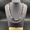Détail de perles en fluorine naturelle violette et verte sur cordon tressé violet - Fluorite