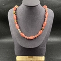 Collier artisanal en pierres naturelles orange rose et vert sur un mannequin gris - Rouge Pastèque (Synthétique)