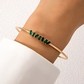 Minimalist gold open bangle featuring rectangular baguette-cut green gemstones on wrist - Rectangular Step Green Rhinestone Style (24778-gold)