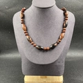 Collier en obsidienne acajou avec perles olives et disques sur un support d'exposition gris - Obsidienne Acajou