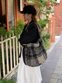 Outdoor-Streetstyle-Aufnahme einer großen schwarz-weiß karierten Plüsch-Tasche - Schwarz Grau Karierter Stil
