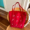 Borsa tote in velluto a coste rosso con scritta Our Future su una sedia in legno - Rosso