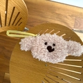 Gros plan du porte-monnaie ours en peluche rose avec texture bouclée et sangle jaune vif - Rose