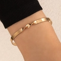 Polished golden twist open cuff bracelet with minimalist flat band design on wrist - Twist Process Flat Band Style (22072-gold)