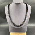 Natural stone necklace with dark translucent round beads on a model display stand - Black Agate