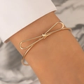 Elegant gold bow-shaped open bangle with polished finish on a female wrist - Minimalist Bow Knot Shape Style (4248-1)