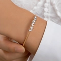 Gold open cuff bracelet featuring eight rectangular step-cut zircon stones on a wrist - Misaligned Step Clear Rhinestone Style (24778-white)