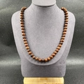 Natural stone necklace featuring brown wheel beads with red hand-woven knotted cord - Mahogany Obsidian