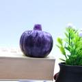 Hand-carved purple natural stone pumpkin figurine on vintage books for home decor - Phosphosiderite