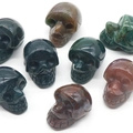 Polished natural crystal skull carvings in various stones and colors for Halloween decor - India Agate