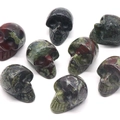 Polished natural bloodstone skull carvings with unique green and red mineral patterns - Dragon Blood Stone