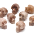 Polished natural sunstone mini crystal skulls set with warm reddish brown crystal textures - Purple Aventurine