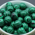 Polished green malachite 8mm round gemstone beads for DIY jewelry making in a ceramic bowl - Malachite (Synthetic)