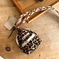 Mini leopard print backpack coin purse with woven lanyard on a wooden tabletop - Brown Leopard