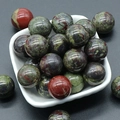 Polished natural 20mm dragon blood stone round balls in a white ceramic bowl - Dragon Blood Stone