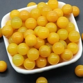 Polished 12mm yellow chalcedony crystal beads for jewelry making in a white tray - Agate