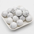 Polished white howlite stone spheres with grey veins in a minimalist white tray - Howlite