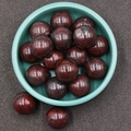 Deep red mottled natural stone spheres in a ceramic bowl for DIY jewelry and crafts - Red Unakite