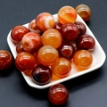 Polished 20mm red agate stone spheres without holes displayed in a white ceramic dish - Red Agate