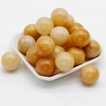 Polished 20mm yellow agate natural stone balls piled in a white ceramic dish - Topaz