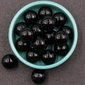 Polished black onyx gemstone sphere beads for DIY jewelry making in a ceramic bowl - Obsidian