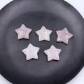 Cinco estrellas de cuarzo rosa pulido en un plato negro para decoración - Cuarzo rosa