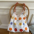 Floral cotton canvas tote bag with woven rope handles shown on a wooden chair - L / Colorful Flower