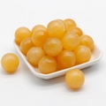 Round smooth 20mm yellow jade stone spheres on a white tray for DIY crafts - Yellow Jade