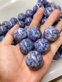 Polished natural sodalite stone sphere featuring deep blue and white marble textures - Sodalite