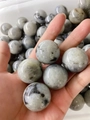 Handheld 30mm natural polished moonstone sphere with blue flash and smooth finish - Labradorite