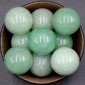 Polished 30mm natural green aventurine crystal spheres displayed in a ceramic bowl - Green Aventurine