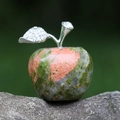Natural green and pink stone apple sculpture with silver rhinestone leaf on gray rock - Unakite