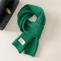 Detail of dark green knit scarf showing ribbed edges and minimalist white woven label - 20x156cm / Green
