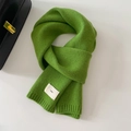 Close-up of vibrant green knit scarf featuring ribbed edges and a minimalist emo fabric tag - 20x156cm / Cyan