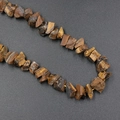 Natural tiger eye raw stone beads showing unique golden brown chatoyancy and texture - Tiger's Eye